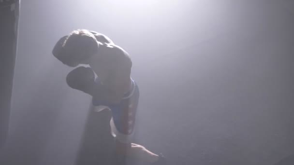 Sac de boxe kickboxer sans chemise comme exercice, tir supérieur, entraînement pour un gros combat — Video