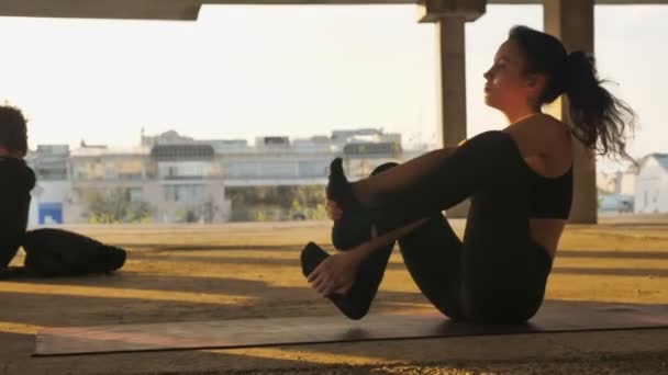 Niña yogui está sentado en navasana en edificio abandonado en verano en la puesta del sol, estilo de vida saludable, concepto de movimiento, concepto de deporte — Vídeo de stock