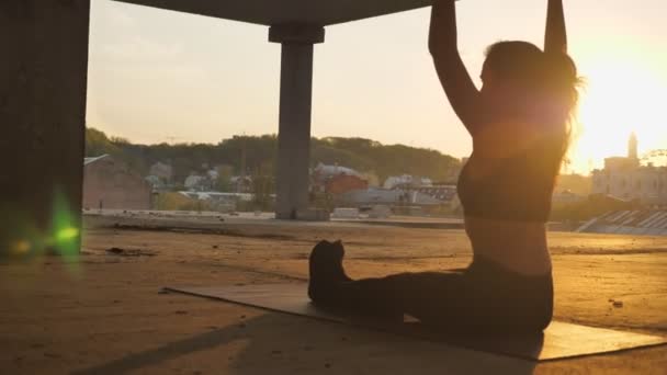 Yogi meisje komt naar paschimottanasana in verlaten gebouw in de zomer op de zonsopgang, verkeer concept, gezonde levensstijl en sport concept, ontspannen concept — Stockvideo