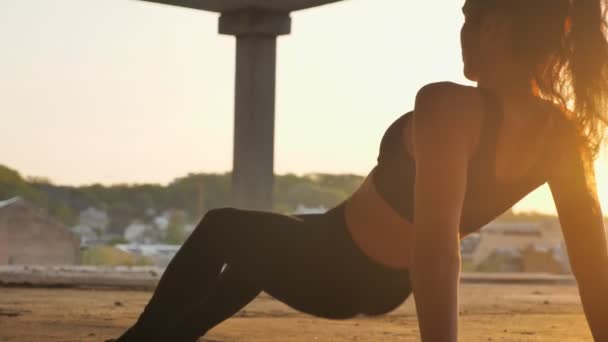 Yogi meisje staat in omgekeerde plank in verlaten gebouw in de zomer op de zonsondergang, gezonde leefstijl, verkeer concept, sport concept — Stockvideo