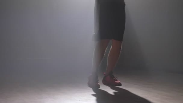 Крупним планом кадри баскетболістів ноги грають з м'ячем в темній туманній кімнаті з димом — стокове відео