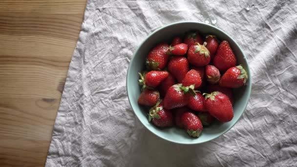 Schüssel mit Erdbeeren auf dem Tisch mit Tischdecke, frische Beeren — Stockvideo