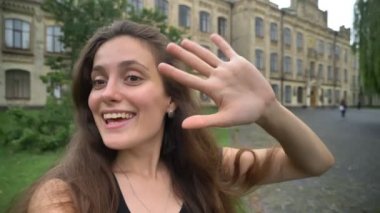 Video çekimi genç çekici kadın blogger veya görüntülü sohbet cadde üzerinde college Kampüsü, açık havada, gündüz var