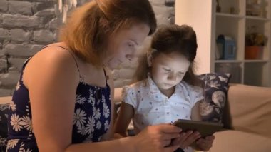 Tablet kullanma ve kanepeye modern adlı ev, Aile kavramı, kapalı oturan küçük çocuğu olan kadın
