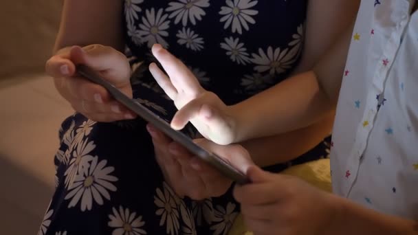 Νέοι μητέρα κάθεται με μικρή κόρη και χρησιμοποιώντας το tablet στο σπίτι, οικογένεια έννοια, σε εσωτερικούς χώρους — Αρχείο Βίντεο