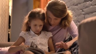 Anne küçük şirin kızı için kitap okuma ve birlikte modern oturma odası, Aile kavramı, kapalı oturan