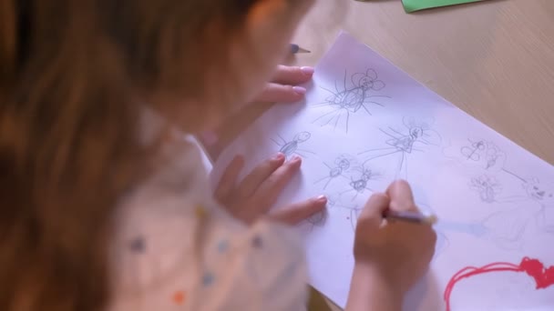 Kid with mom drawing on paper, mother helping daughter with homework, sitting at table, family concept — Stock Video