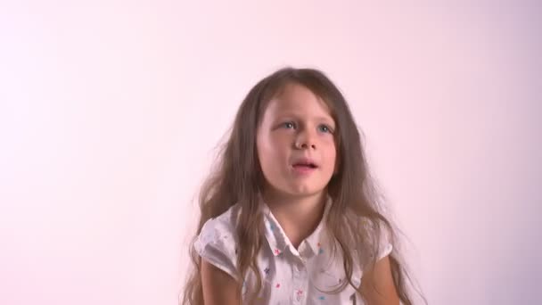 Маленькая милая девочка обнимает плюшевого плюшевого мишку и стоит изолированно на розовом фоне студии — стоковое видео