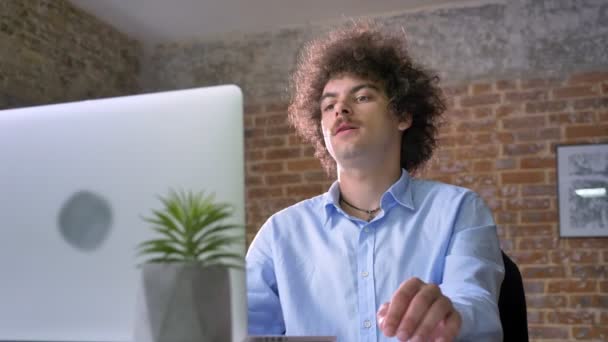 Idea que viene a la mente del programador nerd con el pelo rizado del volumen, trabajando en el ordenador portátil y sentado en la oficina moderna — Vídeos de Stock