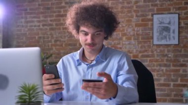 Komik inek ofis çalışanı telefon oturma ve modern ofis içinde kapalı alışveriş, kredi kartı ile fatura ödeme