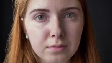 Genç ciddi güzel kadın yüzünü kameraya endişe ve işgal altındaki ifade, siyah arka plan ile seyir yakın portresi