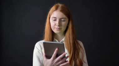 Büyüleyici zencefilli kadın gösteren ekran tablet charomakey içine siyah arka plan üzerine izole kamera ile