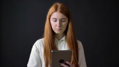 Tablete yazma ve siyah arka plan üzerine izole kamera, içine göstermek chromakey ile gösterilen kadın büyüleyici Zencefilli