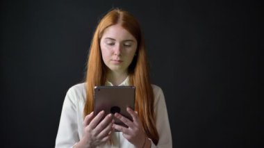 Zencefil tablet ve chromakey gösteren ekran kameraya, mutlu ve neşeli, siyah arka plan yazarak gülümseyen