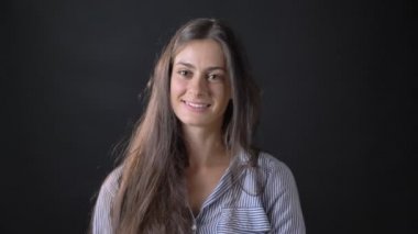 İzole üzerinde siyah arka plan ayakta kameraya gülümseyen ve saçları, dokunmadan çizgili gömlekli çekici genç kadın