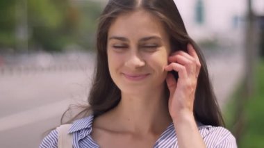 Mutlu genç kadın ile gülümseyen ve kamera, yol yakınında sokakta duran bakarak büyüleyici