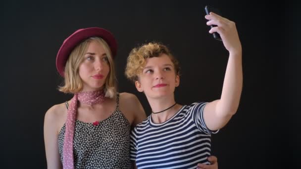 ハグして立っている Selfie に分離された つの魅力的な若いブロンドの女性は黒背景 — ストック動画