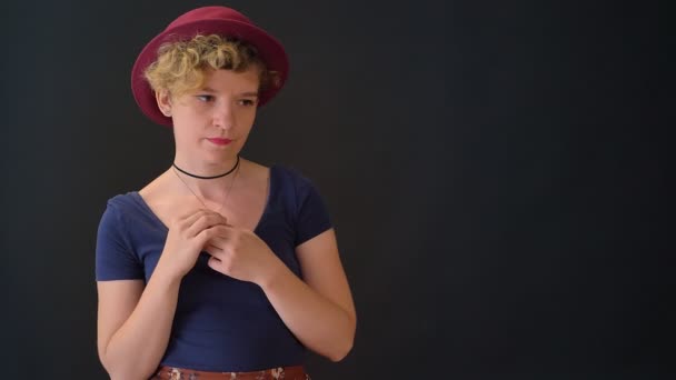 Jonge vrouw bezig met krullend haar hand in hand samen en staande geïsoleerd op zwarte achtergrond — Stockvideo