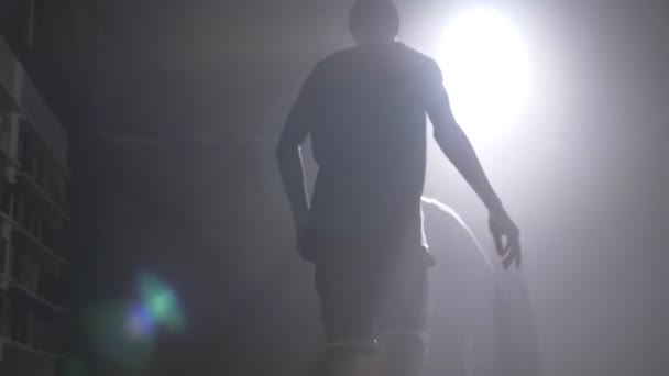 Két kosárlabda játékos sziluettjét játszik egy szobában egy füst és kivilágított — Stock videók