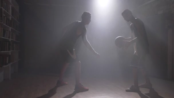 Spelare försöker ta bollen från en annan spelare i rum med rök och strålkastare — Stockvideo