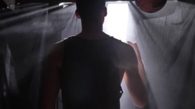 Arkası Karanlık sisli odada bekliyor ve topla oynamayı basketbolcu.