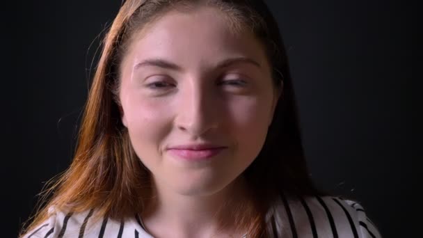 Young beautiful ginger woman looking at camera, isolated on black background, beauty portrait — Stock Video