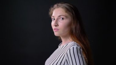 Genç baş dönme ve ayakta kameraya bakarak kadın siyah arka plan üzerine, ciddi ve kendine güvenen izole endişeli
