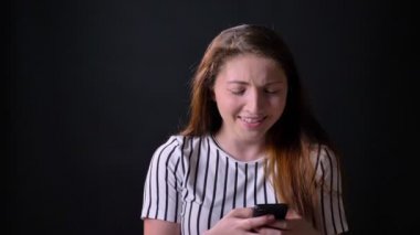 Güzel kadın telefon ve gülme, komik bir şey okuma izole siyah stüdyo arka planda, neşeli ve mutlu