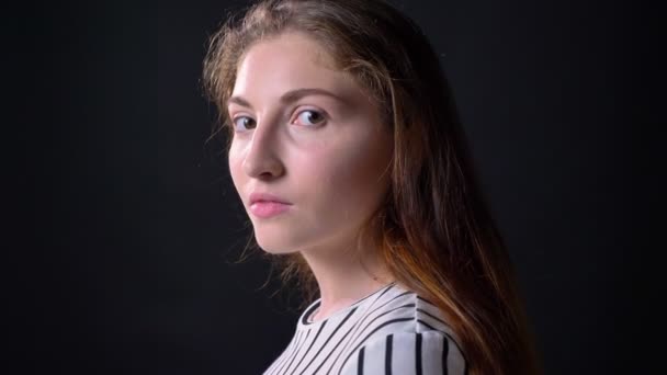 Portrait of beautiful woman turning head and looking at camera, smiling, isolated on black background — Stock Video