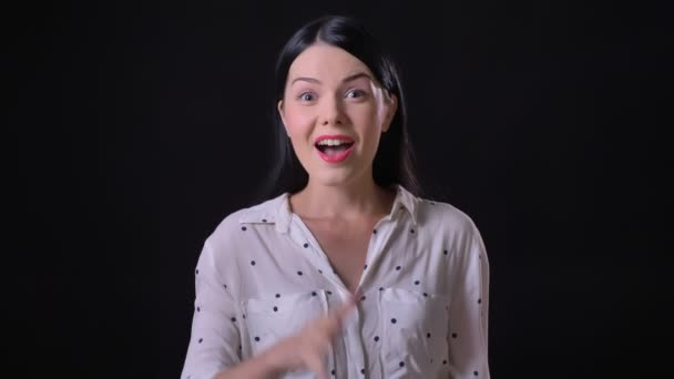 Jolie jeune femme saluant et invitant quelqu'un, debout isolé sur fond noir — Video