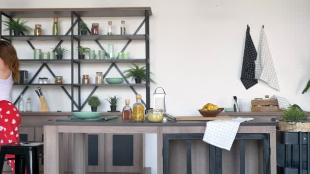 Hermosa esposa de jengibre bailando movimientos sexy en la cocina moderna, feliz y alegre joven mujer divirtiéndose en casa — Vídeos de Stock