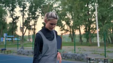 Genç kadın basketbol oyuncu fırlatma topu büyüleyici ve sabah sırasında parkta oynarken