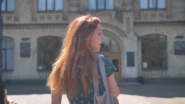 Affascinante zenzero giovane donna che cammina e si gira, sorridendo, andando all'università o al college, bella studentessa — Video Stock