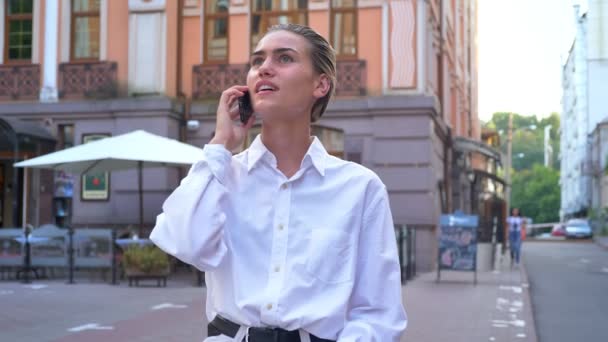 Jonge moderne vrouw is staan op straat en praten over telefoon, afspraak, communicatieconcept, stedelijk concept maakt — Stockvideo