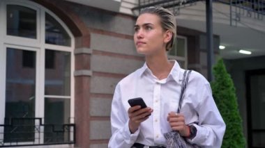 Genç modern kadın Smartphone, sokak ve yazma iletideki çevresinde, izlerken duruyor düşünme kavramı, iletişim kavramı, kentsel kavramı