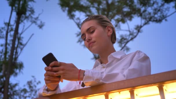 Moderne vrouw staat op brug, bericht aan het typen op smartphone, communicatieconcept, ontspannen concept, onderste weergave — Stockvideo