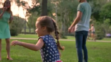 Genç aile yaz aylarında parkta yürüyor, kızı kabarcıklar, çocukluk kavramı yakalıyor