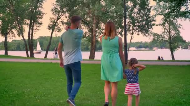 Silhouette der jungen Familie läuft im Park im Sommer, Sonnenuntergang — Stockvideo