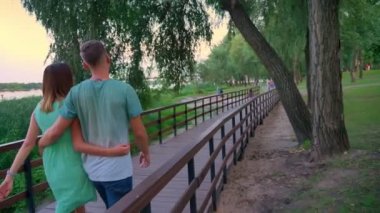 Siluet çift yaz, günbatımı Park yol boyunca yürüyor