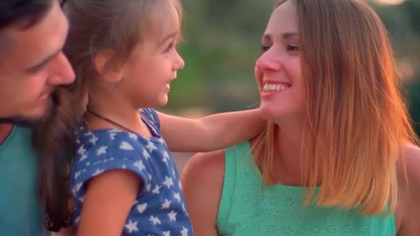 Família jovem está sentado no parque no verão, falando, pôr do sol, comunicar conceito — Vídeo de Stock