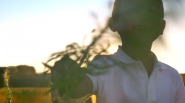 Asyalı erkek ve kız yaz aylarında gündüz, çiçekler, doğa kavramı ile oynarken alanına yürüyor