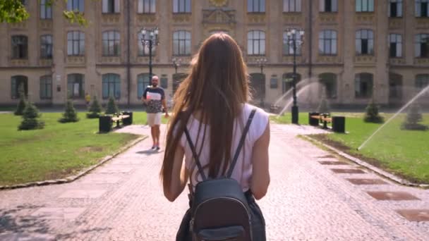 Nette junge Frau dreht sich um und geht im Sommer tagsüber im Park spazieren — Stockvideo