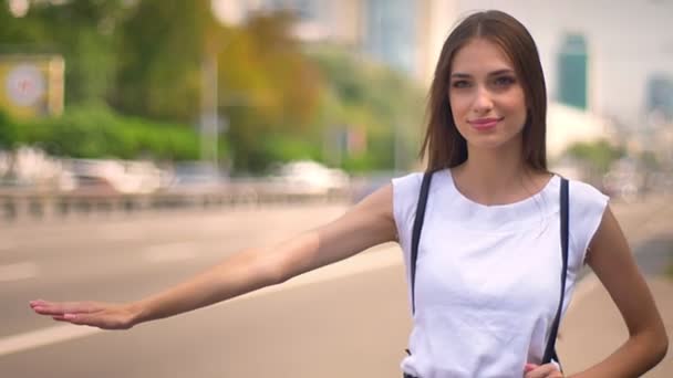 Sexy dame staat op bushalte overdag in de zomer, het vangen van vervoer, onscherpe achtergrond — Stockvideo