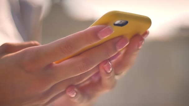 在夏季阳光明媚的日子里 女人的手打字在智能手机上 沟通的概念 模糊的背景 侧面视图 — 图库视频影像