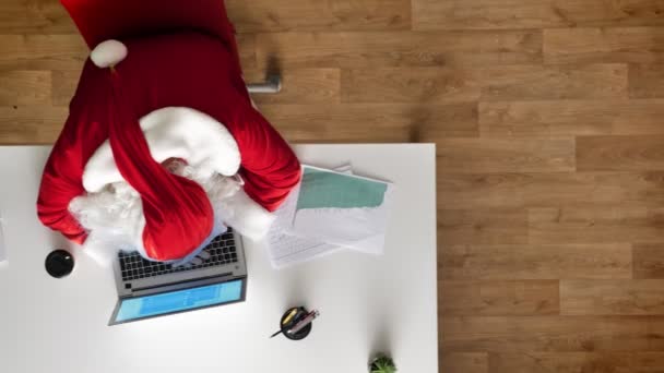 Trött tomte sover i office på en laptop, Flygfoto, top-down skott, dolly skott — Stockvideo