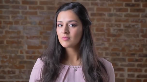 Portrait d'une jeune fille mulâtre confiante regardant dans la caméra et criant, applaudissant, souriant, riant, mur de briques en arrière-plan — Video