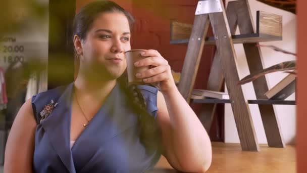 Geschwollene Kaukasierin, die ihren Drink trinkt und mit einem Lächeln in die Kamera schaut — Stockvideo