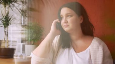 Ağır beyaz modeli yere telefon ile kahve pencere yakınındaki kafede konuşuyor