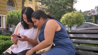 İki balina beyaz kız arkadaşım yakından seyir telefon ve bankta soğutma üzerine basarak