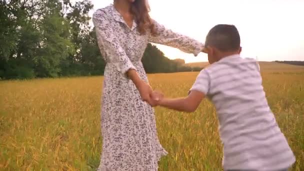 Прекрасна азіатська мати обертається зі своїм маленьким хлопцем на пшеничному полі — стокове відео